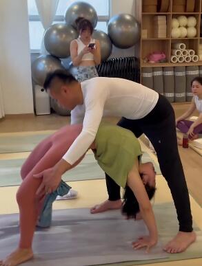 教练帮助学员下腰开肩,专业辅助 一起练瑜伽