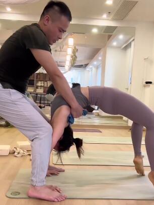 男教练帮助女学员下腰练习