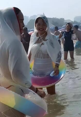 海边玩水的眼镜妹穿防晒衣